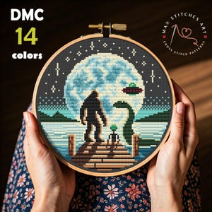 Può includere: Ricamo a punto croce in un telaio di legno con un Bigfoot, un mostro di Loch Ness e un alieno su un molo sotto una luna piena e un UFO. Il testo "DMC 14 colori" è in alto a sinistra. Il testo "MAX STITCHES ART CROSS STITCH PATTERNS" è in alto a destra.
