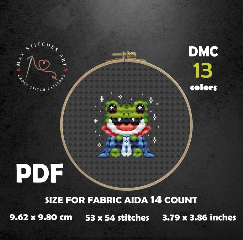 May include: Cross-stitch pattern featuring a green frog with a red mouth and blue cape, set in a wooden embroidery hoop. The pattern is for 53 x 54 stitches and measures 3.79 x 3.86 inches. The pattern uses 13 DMC colors.