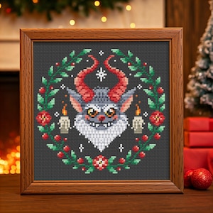 May include: A cross-stitch pattern featuring a gray monster with red horns and a white beard, surrounded by a green wreath with red berries and white candles. The monster has a mischievous grin and large, round eyes.