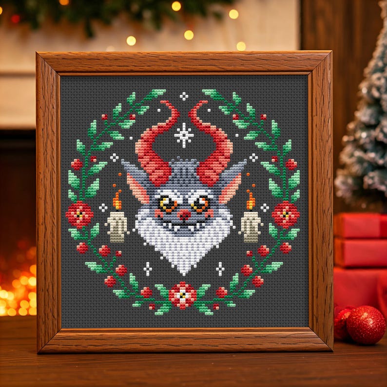 May include: A cross-stitch pattern featuring a gray monster with red horns and a white beard, surrounded by a green wreath with red berries and white candles. The monster has a mischievous grin and large, round eyes.