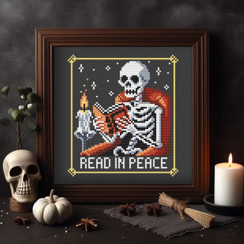 May include: A cross-stitch pattern featuring a skeleton reading a book by candlelight. The skeleton is wearing a red robe and is sitting in a chair. The text "Read in Peace" is below the skeleton.