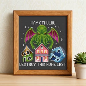 May include: Cross-stitch pattern featuring a green Cthulhu monster with the text "May Cthulhu Destroy This Home Last". The pattern also includes a pink house, a yellow house, and a blue wave.