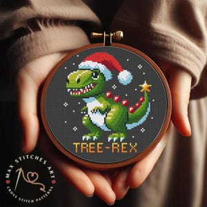 Pode incluir: Um padrão de ponto cruz de um dinossauro verde usando um chapéu de Papai Noel vermelho com o texto "TREE-REX" em um fundo preto.