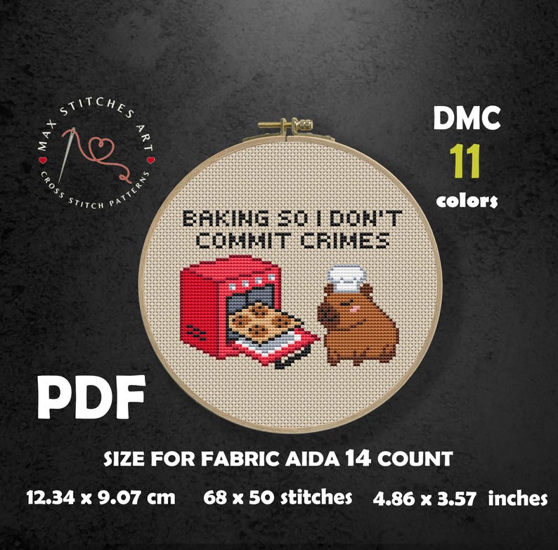 May include: Cross-stitch pattern in a wooden hoop featuring a red oven with cookies and a brown capybara. The text reads "BAKING SO I DON'T COMMIT CRIMES." Includes size information: 4.86 x 3.57 inches.