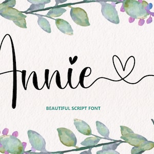Può includere: Un design di font in corsivo nero del nome "Annie" con un piccolo cuore dopo il nome e un cuore più grande alla fine di una linea che si estende dal nome. Il testo "BEAUTIFUL SCRIPT FONT" è sotto il nome.