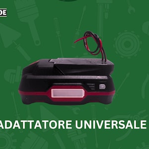 Puede incluir: Un adaptador de batería universal negro y rojo con un cable rojo y negro conectado. El adaptador tiene una etiqueta que dice "ADATTATORE UNIVERSALE".