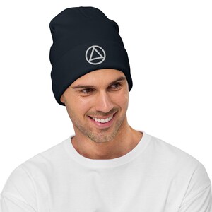 May include: A navy blue beanie with a white circle and triangle design. The beanie is made of a soft, comfortable material and is perfect for keeping your head warm in the winter.