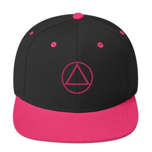 May include: A black and pink baseball cap with a pink triangle inside a circle embroidered on the front.