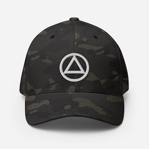 May include: A black and green camouflage baseball cap with a white embroidered triangle symbol inside a circle.