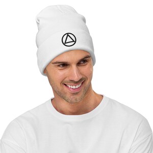 May include: White beanie with a black circle and triangle design.