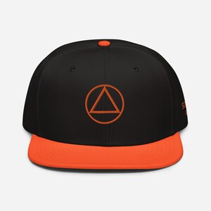 May include: A black and orange baseball cap with an orange triangle inside a circle embroidered on the front.