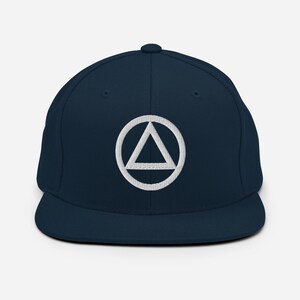 May include: A navy blue baseball cap with a white embroidered symbol of a triangle inside a circle.