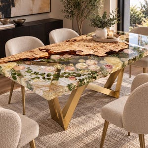 May include: A rectangular dining table featuring a live edge wood slab with a burl grain pattern, integrated with a clear resin section containing embedded dried flowers and greenery, supported by a gold-toned metal V-shaped base frame.