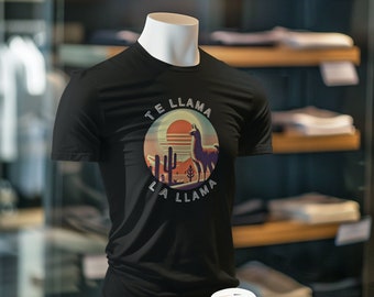 May include: Black t-shirt with a graphic of a llama in a desert landscape with the text "Te Llama La Llama" in a retro style font.