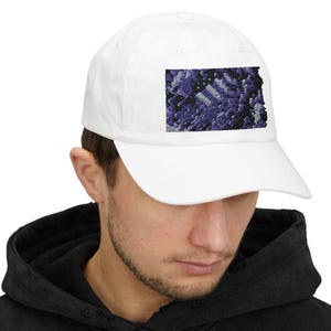 May include: A white baseball cap with a purple and blue abstract design on the front.