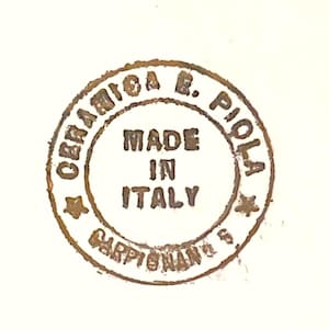 Peut inclure: Un tampon circulaire brun avec le texte "Ceramica R. Piola" et "Made in Italy" &agrave; l'int&eacute;rieur. Le tampon comprend &eacute;galement le texte "Carpi (Modena) Italy".