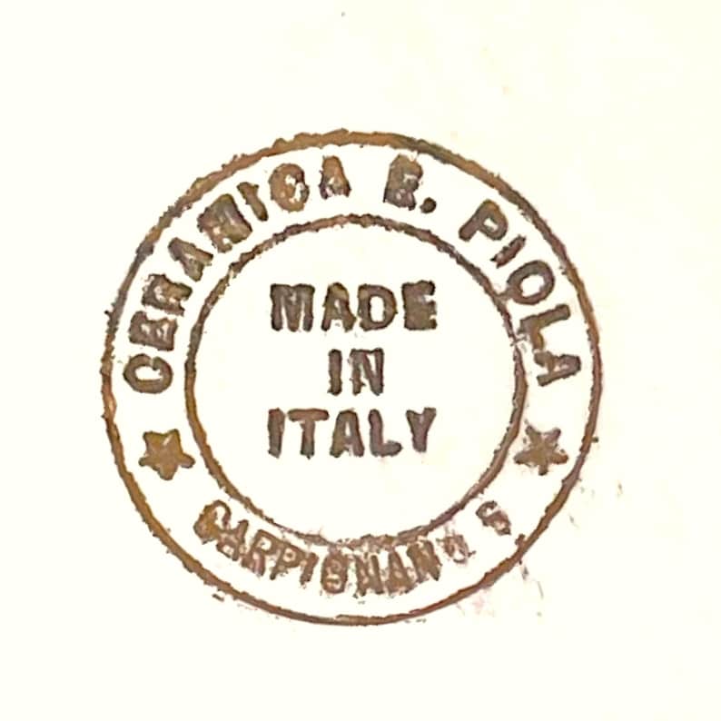 Peut inclure: Un tampon circulaire brun avec le texte "Ceramica R. Piola" et "Made in Italy" &agrave; l'int&eacute;rieur. Le tampon comprend &eacute;galement le texte "Carpi (Modena) Italy".