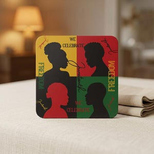 May include: Square coaster with a Juneteenth theme. The design features four quadrants in yellow, red, green, and black, each with a silhouette of a person and the words "We Celebrate", "Juneteenth", and "Freedom".