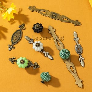 May include: An assortment of antique-style cabinet hardware, including drawer pulls and knobs. The hardware features a mix of metal and ceramic elements in various colors, including bronze, white, green, and black. The text "LeisurelyRig" is visible on the image.