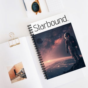May include: A spiral bound notebook with a colorful image of an astronaut standing on a planet with a galaxy in the background. The notebook cover has the text "Starbound." printed on it.