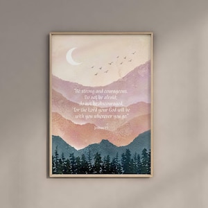 Könnte beinhalten: Ein gerahmter Kunstdruck mit einer Aquarelllandschaft mit Bergen in Rosa-, Orange- und Blautönen. Ein Halbmond und Vögel sind am Himmel. Der Text lautet: „Sei stark und mutig...“ Josua 1:9.