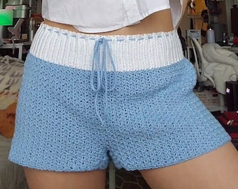 Könnte beinhalten: Hellblaue Häkelshorts mit einem weißen Häkelbund und einem Kordelzug.