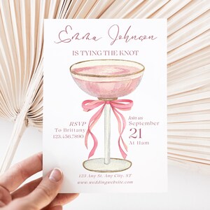 Pode incluir: Convite de casamento rosa com uma ilustração de taça de champanhe e o texto "Emma Johnson is tying the knot" e "Join us September 21 at Ham".