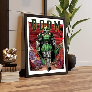 May include: Framed comic art print featuring Doctor Doom. The artwork depicts Doctor Doom in a green hooded cloak and armor, striding forward. The word "DOOM" is displayed in green block letters above the character. The background is a red and orange cityscape.