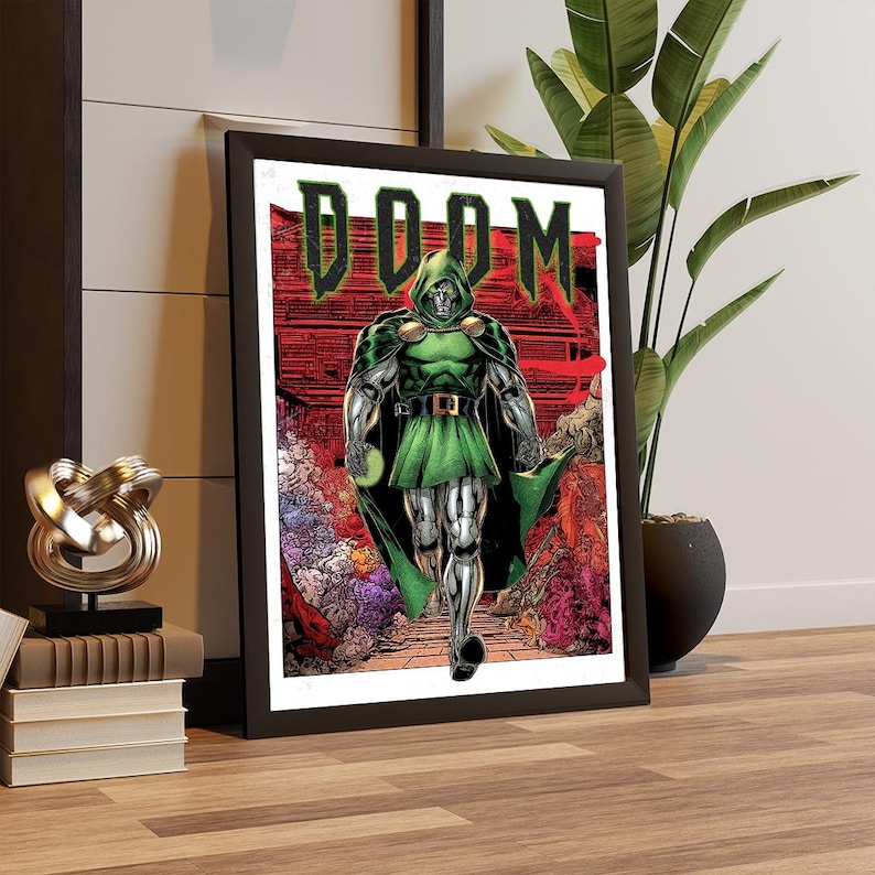 May include: Framed comic art print featuring Doctor Doom. The artwork depicts Doctor Doom in a green hooded cloak and armor, striding forward. The word "DOOM" is displayed in green block letters above the character. The background is a red and orange cityscape.