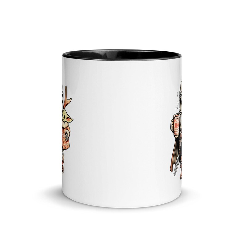 Op de afbeelding: Witte keramische mok met een zwarte binnenkant. De mok heeft cartoon illustraties aan elke kant. De ene kant toont een personage met geweien, de andere een figuur met een drankje. Een leuke, thematische koffiemok.