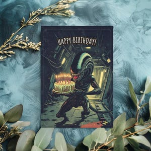 Puede incluir: Tarjeta de cumplea&ntilde;os con una ilustraci&oacute;n de un Alien sosteniendo un pastel de cumplea&ntilde;os con velas encendidas. La tarjeta tiene la frase "HAPPY BIRTHAY!". El Alien est&aacute; representado en un entorno industrial oscuro.