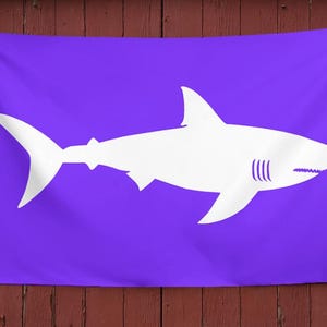 May include: A purple flag with a white silhouette of a shark.