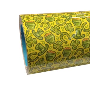 May include: A roll of yellow vinyl with a repeating pattern of green shamrocks, gold coins, leprechaun hats, and horseshoes.