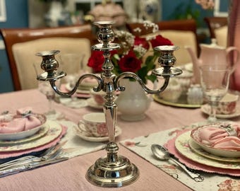 Centro de mesa vintage com três braços, banhado a prata e com formato curvo para velas.