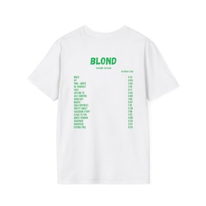 Op de afbeelding: Wit T-shirt met het woord "BLOND" in groene blokletters, met daaronder een lijst met songtitels en -lengtes. De tekst "FRANK OCEAN" staat onder "BLOND". De datum "20 AUGUST 2016" staat rechtsboven.