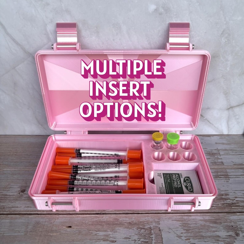 May include: A pink medical case with the text "MULTIPLE INSERT OPTIONS!" Syringes, vials, and alcohol prep pads are visible inside. The case has a handle and latches for secure closure. The case is open, revealing its contents.