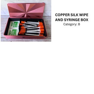 May include: A copper-colored rectangular storage box with a hinged lid featuring a sunburst pattern. Inside are several clear syringes with orange caps and two white alcohol prep pads. The text COPPER SILK WIPE AND SYRINGE BOX Category: B is visible.