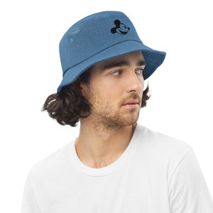 Man with brown hair wearing Blue Denim bucket hat with embroidered retro Mickey Mouse profile and a white tshirt