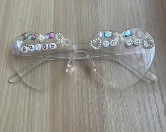 Occhiali personalizzati a forma di cuore L'accessorio più cercato per addio al nubilato, matrimoni e eventi indimenticabili! ✨ Disponibili in nero e bianco, con stampa di iniziali e data dell'evento