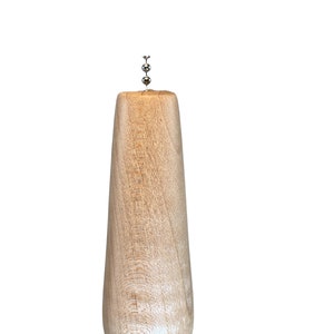 May include: A wooden bottle stopper with a silver metal top. The stopper is shaped like a pear and has a smooth, light brown finish.