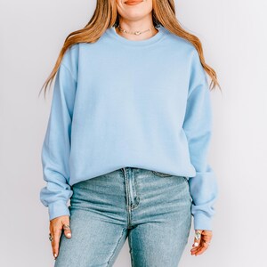 K&ouml;nnte beinhalten: Hellblaues Sweatshirt mit Rundhalsausschnitt und langen &Auml;rmeln. Das Sweatshirt wird mit hellblauen Jeans getragen. Das Model tr&auml;gt eine Halskette und Ringe.