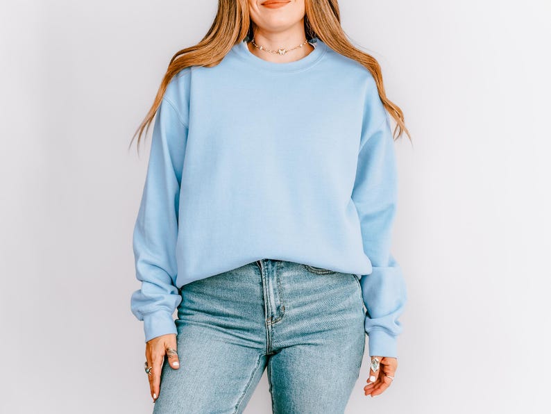 K&ouml;nnte beinhalten: Hellblaues Sweatshirt mit Rundhalsausschnitt und langen &Auml;rmeln. Das Sweatshirt wird mit hellblauen Jeans getragen. Das Model tr&auml;gt eine Halskette und Ringe.