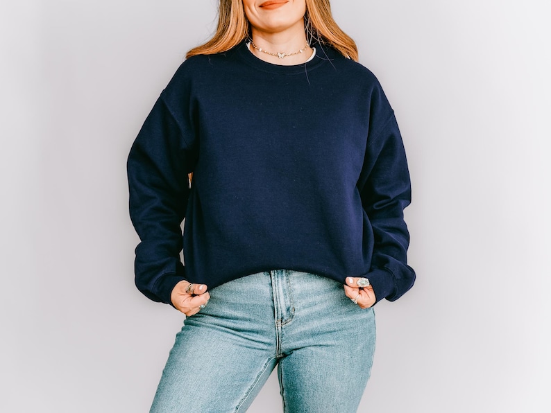 K&ouml;nnte beinhalten: Ein marineblaues Sweatshirt mit Rundhalsausschnitt und langen &Auml;rmeln. Das Sweatshirt wird mit hellblauen Jeans kombiniert. Das Outfit ist schlicht und l&auml;ssig, geeignet f&uuml;r den Alltag.