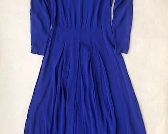 Puede incluir: Un vestido largo azul real de manga larga con cuello de encaje blanco.