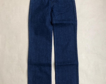 Jeansy dziecięce w kolorze ciemnoniebieskim z lat 70. Rozmiar: 11 lat, szerokość: 25 cali. Wysoki stan, luźny krój, proste nogawki, kieszenie z tyłu z przeszyciem w kształcie litery X, wysokiej jakości jeans
