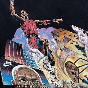 Może przedstawiać: Czarny vintage T-shirt z nadrukiem graficznym koszykarza w powietrzu, wykonującego wsad. Koszykarz ma na sobie czerwoną i białą koszulkę oraz białe buty. Tło to kolorowe miasto z budynkami i chmurami.