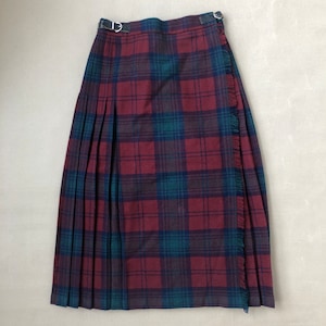 May include: A red, green, and black plaid kilt with a fringed edge and a leather strap with a buckle.