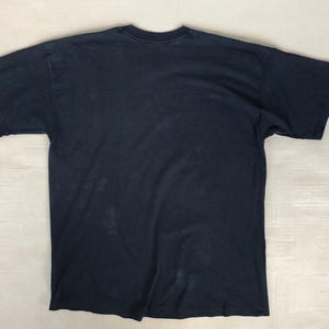 Może przedstawiać: Koszulka w ciemnoniebieskim kolorze z kr&oacute;tkimi rękawami i okrągłym dekoltem.