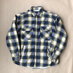 Peut inclure: Une chemise en flanelle à carreaux bleus et jaunes avec un devant boutonné et des manches longues. La chemise a deux poches poitrine et une doublure en polaire.