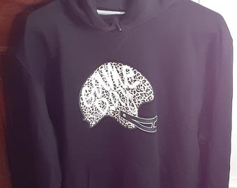 May include: Black hooded sweatshirt with a front pocket and a white and tan leopard print American football helmet graphic. The sweatshirt is hanging on a white hanger.